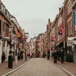 Venlo, Niederlande: Eine Kopfsteinpflasterstraße, die von Backsteingebäuden gesäumt ist.